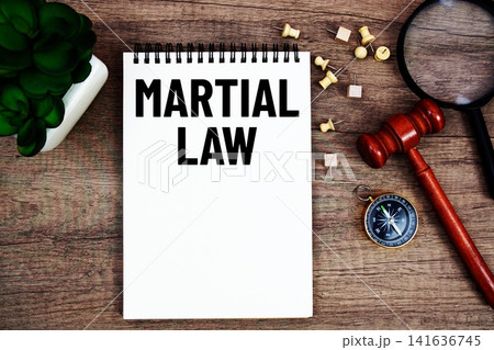 Martial Law message written on notepad with wood gavel and magnifying glass flat lay on wooden background Martial Law message written on notepad with wood gavel and magnifying glass flat lay on wooden background 141636745