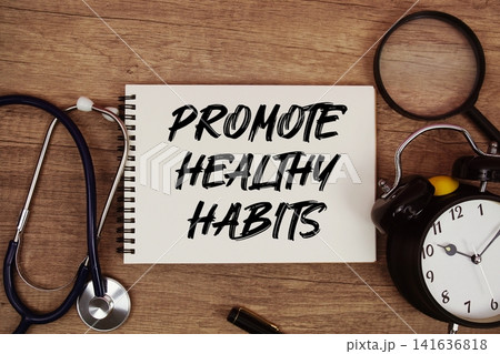 Promote Healthy Habits text written on notepad with stethoscope, magnifying glass and alarm clock on wooden background Promote Healthy Habits text written on notepad with stethoscope, magnifying glass and alarm clock on wooden background 141636818
