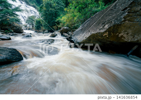 Beautiful waterfall in lush tropical green forest. Nature landscape. Mae Ya Waterfall is situated in Doi Inthanon National Park, Chiang Mai, Thailand. Waterfall flows through jungle on mountainside. 141636854