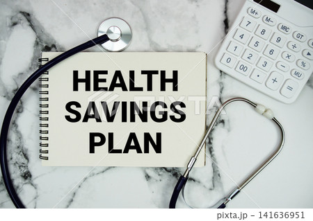 Health Savings Plan text written on notepad with stethoscope and calculator on marble background Health Savings Plan text written on notepad with stethoscope and calculator on marble background 141636951