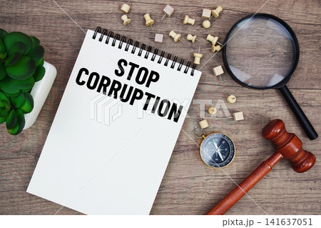 Stop Corruption message written on notepad with wood gavel and magnifying glass flat lay on wooden background 141637051