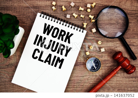 Work Injury Claim message written on notepad with wood gavel and magnifying glass flat lay on wooden background Work Injury Claim message written on notepad with wood gavel and magnifying glass flat lay on wooden background 141637052