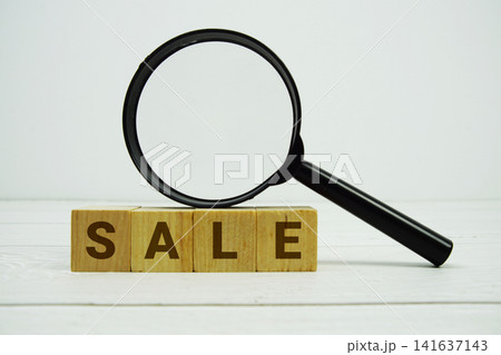 SALE alphabet letters with magnifying glass on wooden background SALE alphabet letters with magnifying glass on wooden background 141637143