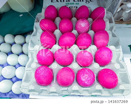 Bright pink dyed eggs in a cardboard carton on display at a market - 07.05.2026, Auburn WA, USA. 141637269