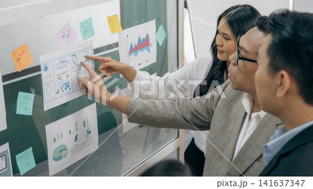 Business team analyzing marketing data and financial charts during corporate strategy meeting, collaborative planning session with analytics dashboard, brainstorming and project development discussion Business team analyzing marketing data and financial charts during corporate strategy meeting, collaborative planning session with analytics dashboard, brainstorming and project development discussion 141637347