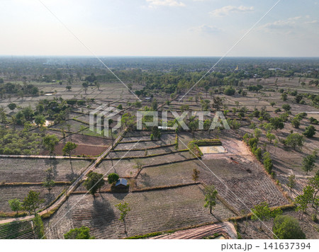 Aerial view of rural agricultural landscape with farmland plots, dirt roads, ponds, and scattered trees. Countryside land use and sustainable farming. Sustainable agriculture and rural development. 141637394