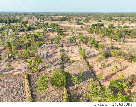 Aerial view of rural agricultural landscape with farmland plots, dirt roads, ponds, and scattered trees. Countryside land use and sustainable farming. Sustainable agriculture and rural development. 141637395