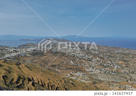 Panoramic high aerial view of Santorini island landscape with traditional vineyard fields and white village in Greece for agricultural nature travel stock background Panoramic high aerial view of Santorini island landscape with traditional vineyard fields and white village in Greece for agricultural nature travel stock background 141637437