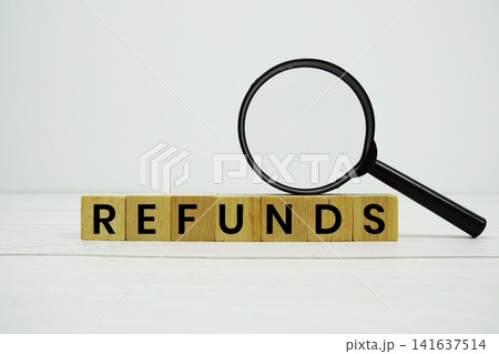 REFUNDS alphabet letters with magnifying glass on wooden background REFUNDS alphabet letters with magnifying glass on wooden background 141637514