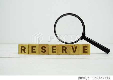 RESERVE alphabet letters with magnifying glass on wooden background 141637515