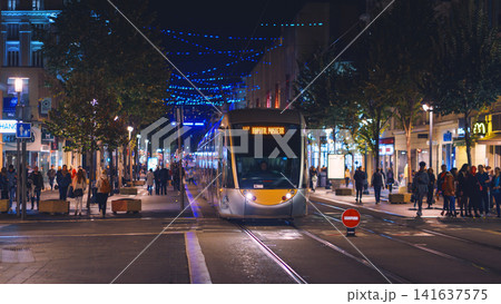 Nice, France - November 2, 2018 - Tram at night on Massena square with pedestrians Nice, France - November 2, 2018 - Tram at night on Massena square with pedestrians 141637575