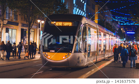 Nice, France - November 2, 2018 - Tram at night on Massena square with pedestrians 141637576