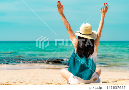 Woman raising both arms in celebration on a tropical beach during a sunny summer vacation. Freedom, happiness, wellness, healthy lifestyle. Summer holiday, travel freedom, wellness, relaxation. Woman raising both arms in celebration on a tropical beach during a sunny summer vacation. Freedom, happiness, wellness, healthy lifestyle. Summer holiday, travel freedom, wellness, relaxation. 141637685