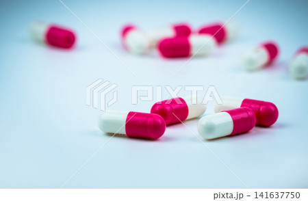 Close up of pink and white prescription capsule medication, pharmaceutical healthcare concept for pharmacy, hospital treatment and pharmaceutical industry. Prescription medication. Drug industry. Close up of pink and white prescription capsule medication, pharmaceutical healthcare concept for pharmacy, hospital treatment and pharmaceutical industry. Prescription medication. Drug industry. 141637750