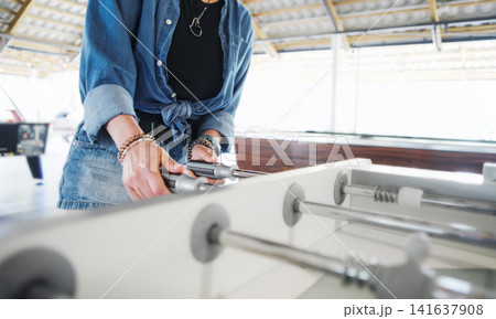 Woman Playing Foosball At An Entertainment Center Woman Playing Foosball At An Entertainment Center 141637908