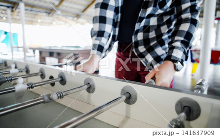 Men Playing Foosball With Friends Men Playing Foosball With Friends 141637909