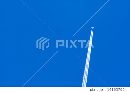 Airplane with white condensation tracks. Jet plane on blue sky and white clouds with vapor trail. Travel by airplane concept. Trails of exhaust gas from airplane engine. Aircraft with white stripes. Airplane with white condensation tracks. Jet plane on blue sky and white clouds with vapor trail. Travel by airplane concept. Trails of exhaust gas from airplane engine. Aircraft with white stripes. 141637994