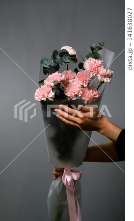 Bouquet of pink carnations on a gray background. Florist assembly a bouquet to order Bouquet of pink carnations on a gray background. Florist assembly a bouquet to order 141638027