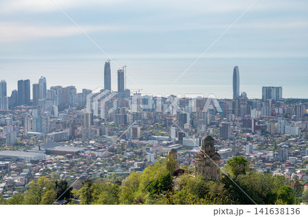 Coastal city skyline with modern highrises and old church on hillside. 141638136