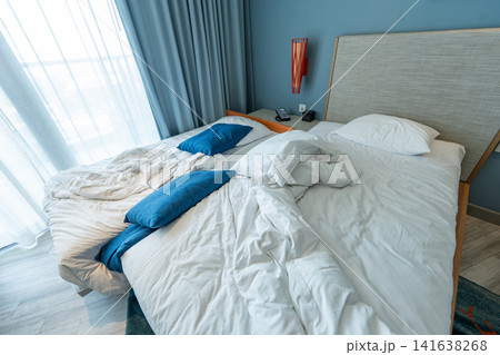 Portable rollaway extra bed with untidy linens prepared for housekeeping after guest checkout. Portable rollaway extra bed with untidy linens prepared for housekeeping after guest checkout. 141638268