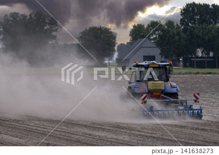 Blue Tractor Cultivating Dry Dusty Field Blue Tractor Cultivating Dry Dusty Field 141638273