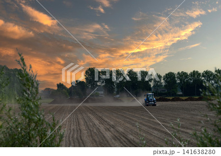 Blue Tractor Cultivating Dry Dusty Field Blue Tractor Cultivating Dry Dusty Field 141638280