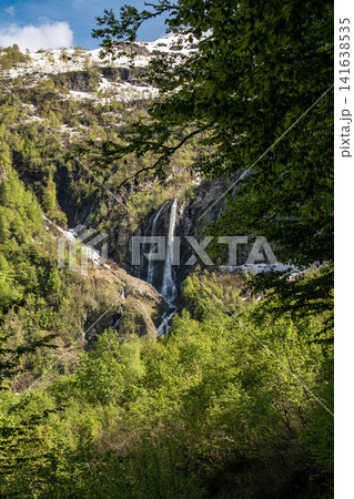 Polikarpiya waterfall cascading down rocky cliff with lush green vegetation - Sochi, Russia Polikarpiya waterfall cascading down rocky cliff with lush green vegetation - Sochi, Russia 141638535