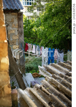 Colorful laundry drying on clothesline outside old village house - traditional rural life Romania Colorful laundry drying on clothesline outside old village house - traditional rural life Romania 141638556