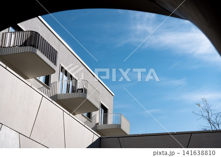 Modern Munich Residential Complex - Upward Perspective - Contemporary White Architecture Against Blue Sky Modern Munich Residential Complex - Upward Perspective - Contemporary White Architecture Against Blue Sky 141638810