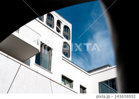 Modern Munich Residential Complex - Upward Perspective - Contemporary White Architecture Against Blue Sky Modern Munich Residential Complex - Upward Perspective - Contemporary White Architecture Against Blue Sky 141638832