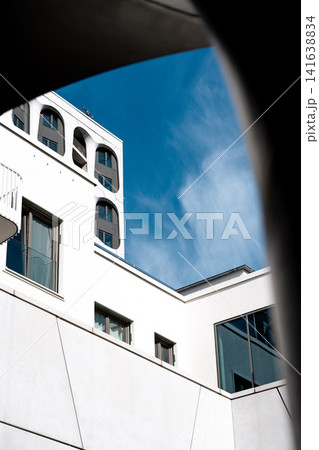 Modern Munich Residential Complex - Upward Perspective - Contemporary White Architecture Against Blue Sky Modern Munich Residential Complex - Upward Perspective - Contemporary White Architecture Against Blue Sky 141638834