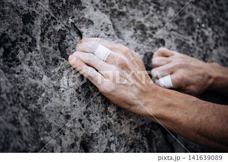 Climber Using Side Pocket Grip With Taped Fingers On Rock Surface: Close Up Of Precision Hand Placement Outdoors Climber Using Side Pocket Grip With Taped Fingers On Rock Surface: Close Up Of Precision Hand Placement Outdoors 141639089