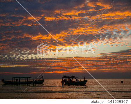 Traditional Fishing Boats At Sunset On Koh Rong Island Cambodia: Golden Hour Seascape With Silhouettes And Calm Ocean Waves Traditional Fishing Boats At Sunset On Koh Rong Island Cambodia: Golden Hour Seascape With Silhouettes And Calm Ocean Waves 141639567