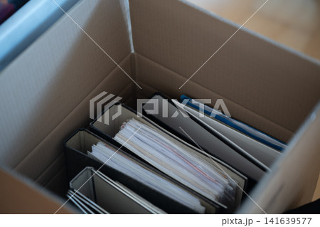 Open Cardboard Box With Organized Paper Documents And Folders Stored Inside For Archiving And Moving Purposes Open Cardboard Box With Organized Paper Documents And Folders Stored Inside For Archiving And Moving Purposes 141639577