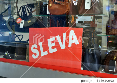 Retail sale window display with red sleva sign and leather handbags in prague store for shop banner background and storefront promotional design. Discount sign in Czech Retail sale window display with red sleva sign and leather handbags in prague store for shop banner background and storefront promotional design. Discount sign in Czech 141639658