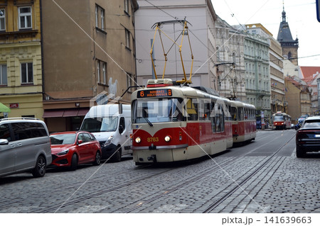 Front view of red Prague tram number six on a cobblestone road for urban transit banner and travel background Front view of red Prague tram number six on a cobblestone road for urban transit banner and travel background 141639663