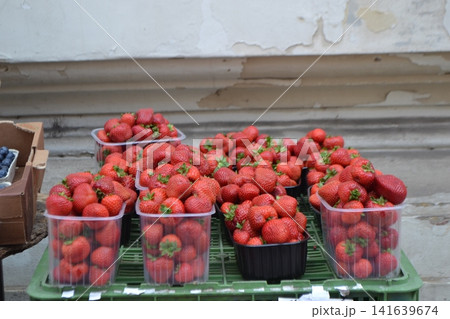 Fresh strawberries in plastic punnets at Prague street market for food background and summer banner Fresh strawberries in plastic punnets at Prague street market for food background and summer banner 141639674