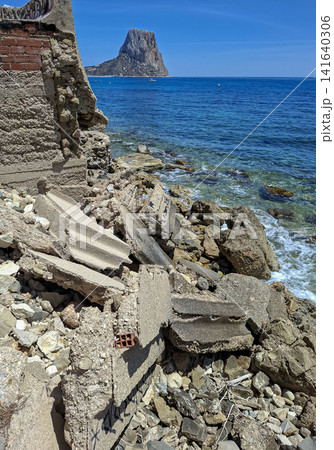 Scenic view of Penon de Ifach rock landmark by the sea and collapsed concrete ruins in Calpe, Spain 141640306