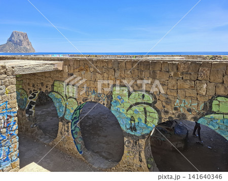 Calpe, Spain - May 27, 2026.Graffiti on stone arches of abandoned Ricardo Bofill complex near Mediterranean coast with Penon de Ifach in view Calpe, Spain - May 27, 2026.Graffiti on stone arches of abandoned Ricardo Bofill complex near Mediterranean coast with Penon de Ifach in view 141640346