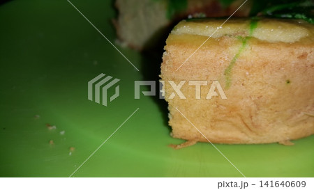 Close up shot of the texture of homemade sponge cake filling on a green tray. Close up shot of the texture of homemade sponge cake filling on a green tray. 141640609