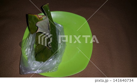 Serabi, lupis, and injin are still wrapped in banana leaves and plastic. Serabi, lupis, and injin are still wrapped in banana leaves and plastic. 141640734