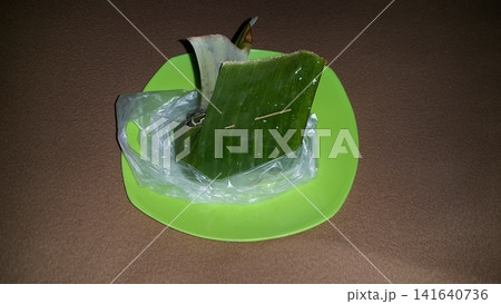 Serabi, lupis, and injin are still wrapped in banana leaves and plastic. Serabi, lupis, and injin are still wrapped in banana leaves and plastic. 141640736