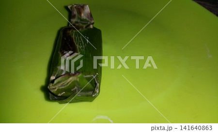 Shot of chicken lemper still wrapped in pisan leaves. Shot of chicken lemper still wrapped in pisan leaves. 141640863
