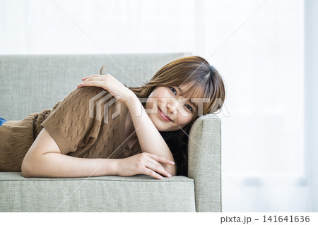 ソファーに横になる若い女性 ソファーに横になる若い女性 141641636