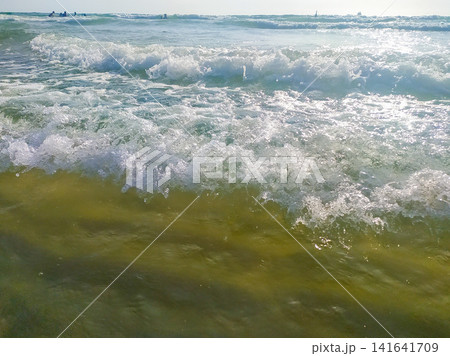 A vibrant coastal scene capturing turquoise ocean waves crashing in the sunlight. This refreshing, nobody view evokes tranquility and summer wanderlust, ideal for travel, wellness, or decor concepts. A vibrant coastal scene capturing turquoise ocean waves crashing in the sunlight. This refreshing, nobody view evokes tranquility and summer wanderlust, ideal for travel, wellness, or decor concepts. 141641709
