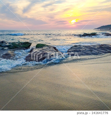 Experience a serene ocean sunset over a rocky shoreline as gentle waves crash. This peaceful coastal scene evokes calm feelings, perfect for wellness or travel projects. Nobody. Experience a serene ocean sunset over a rocky shoreline as gentle waves crash. This peaceful coastal scene evokes calm feelings, perfect for wellness or travel projects. Nobody. 141641776