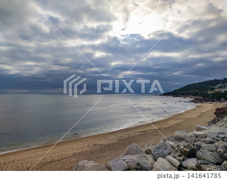 Dramatic coastal scenery featuring a serene, empty beach under a heavy, moody cloudscape. Nobody is present in this peaceful, atmospheric seascape, perfect for themes of solitude and calm. Dramatic coastal scenery featuring a serene, empty beach under a heavy, moody cloudscape. Nobody is present in this peaceful, atmospheric seascape, perfect for themes of solitude and calm. 141641785