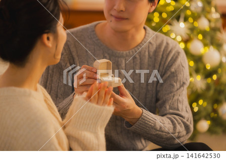 クリスマスプレゼントを渡す若いカップル クリスマスプレゼントを渡す若いカップル 141642530