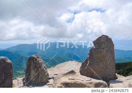 美ヶ原高原の最高峰・王ヶ頭の山頂石碑と夏の青空に広がる山並み 美ヶ原高原の最高峰・王ヶ頭の山頂石碑と夏の青空に広がる山並み 141642675