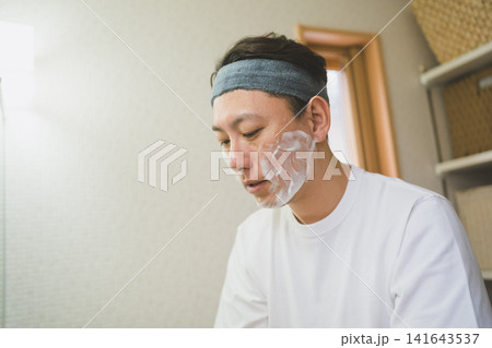 洗面所で下を向いて泡洗顔をする40代男性 洗面所で下を向いて泡洗顔をする40代男性 141643537
